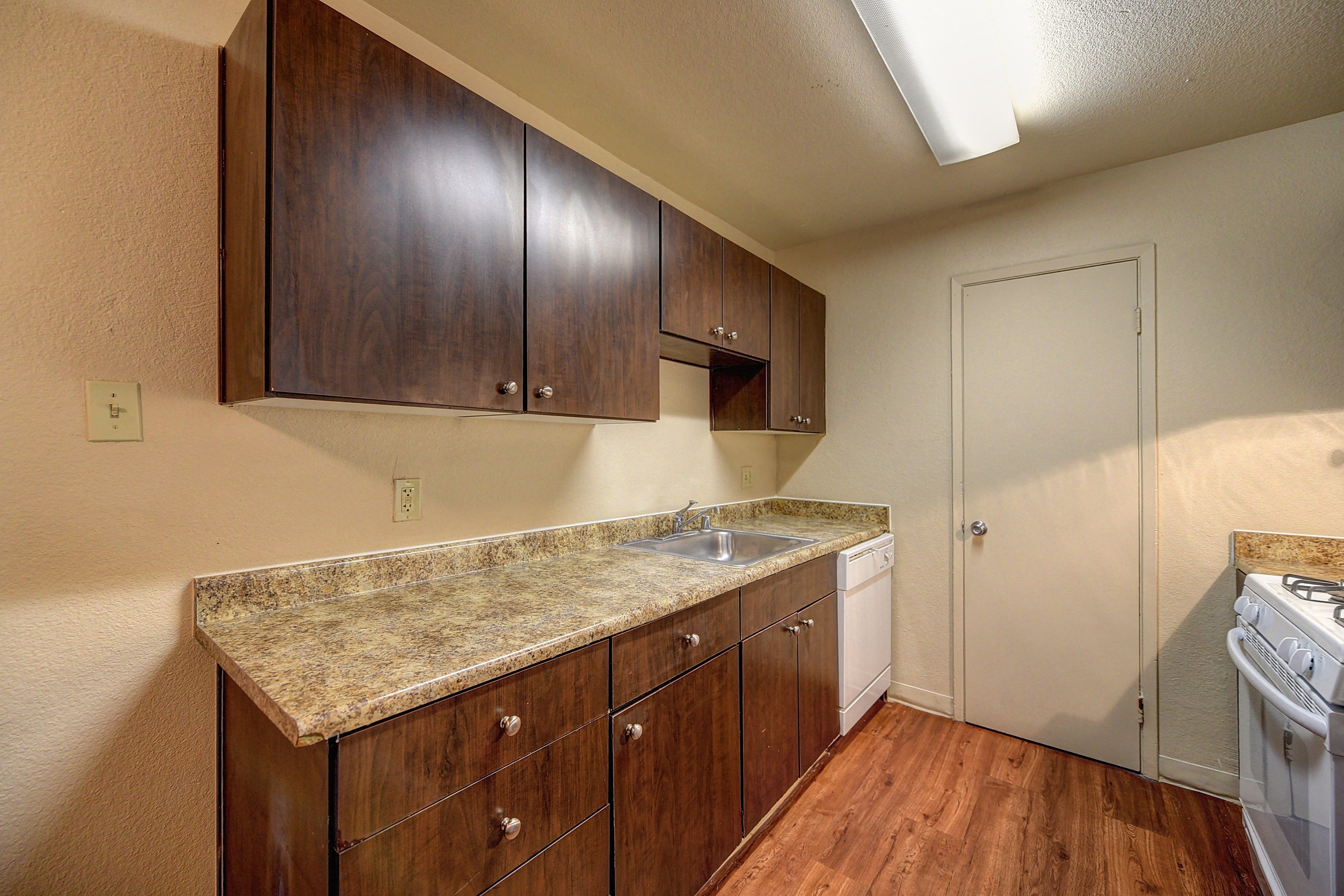 Kitchen with  Granite Quartz Counter Countertop, Refrigerator, Stove, Hardwood Inspired Wood Floor